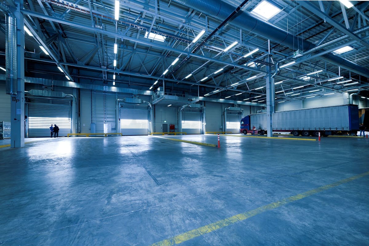 L’IA et la télématique révolutionnent la logistique : économies en millions pour les entreprises françaises Large warehouse interior with docked truck, ideal for logistics and warehousing.